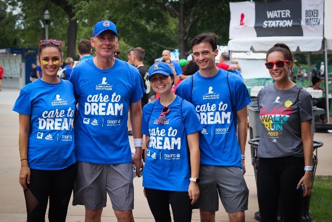 Associates wearing Sears Care to Dream T-shirts smile as they prepare for the event.