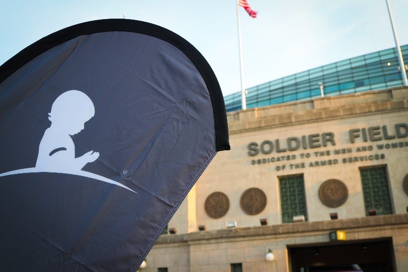 A St. Jude banner waves in the wind against the backdrop of Soldier Field in Chicago.